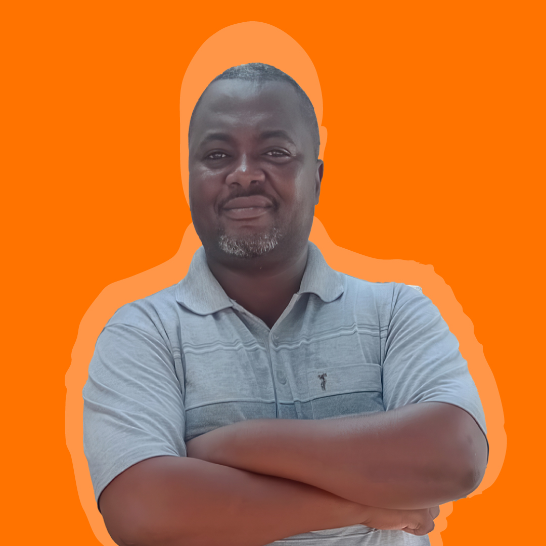 Dionísio Carvalho, membro do Departamento Comercial do Entreposto Comercial do Benvindo, posando com braços cruzados sobre fundo laranja institucional.