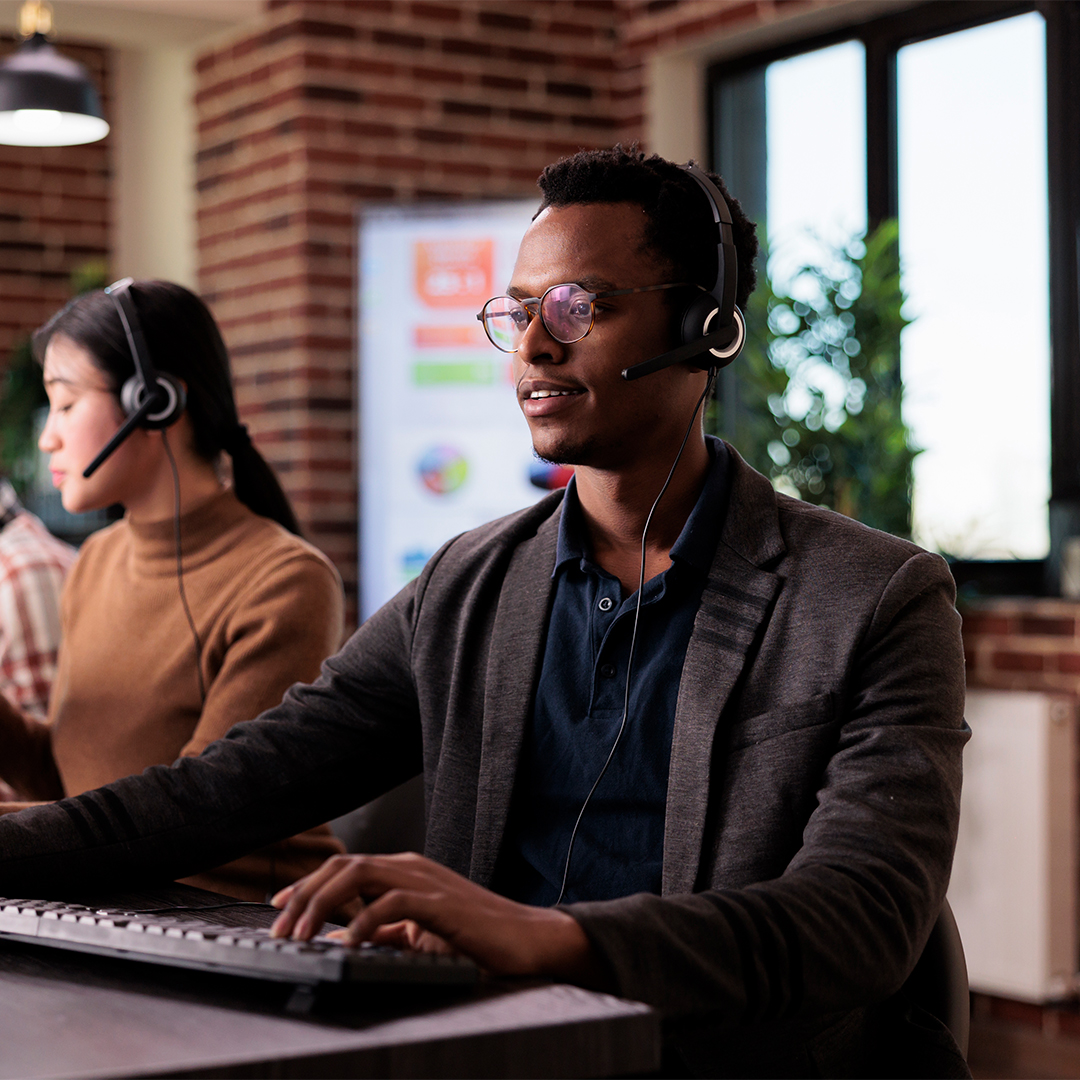 Homem com auscultadores e microfone a prestar suporte ao cliente num call center